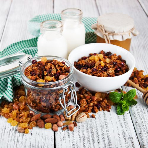 Homemade granola with nuts, milk and honey on a wooden table
